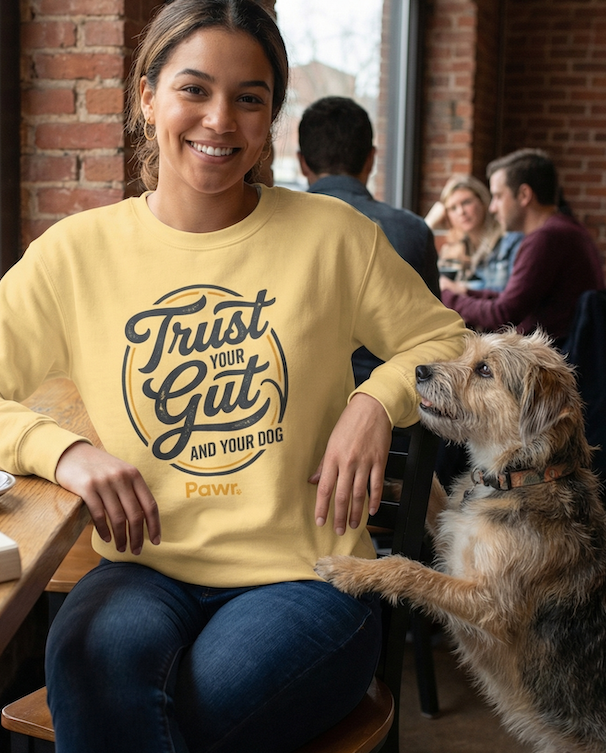 Woman in a yellow sweatshirt with a dog in a casual setting