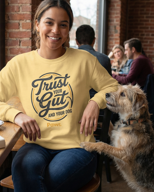 Woman in a yellow sweatshirt with a dog in a casual setting