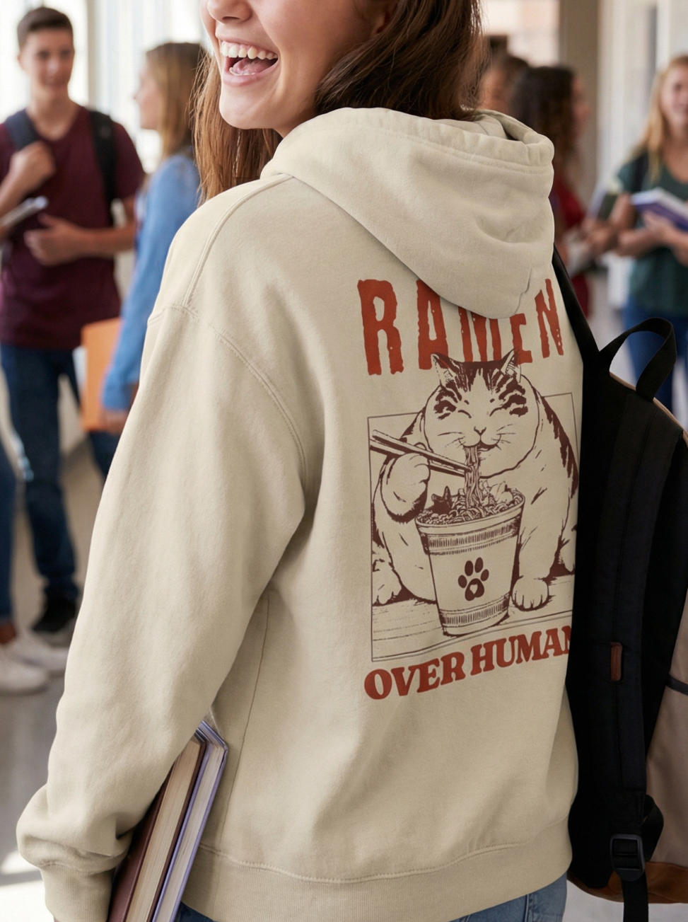 College student wearing beige ramen over humans cat hoodie in school hallway