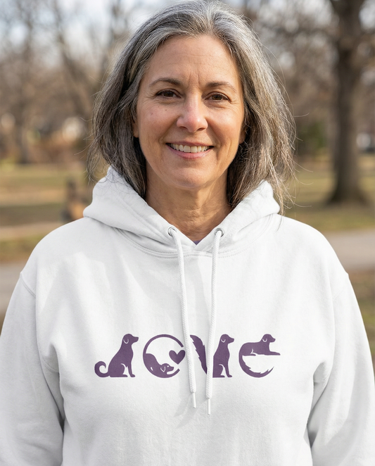 Woman smiling outdoors wearing a white PAWR dog love hoodie with minimalist purple dog graphic, cozy unisex fit, perfect for dog moms, dog dads, and everyday dog lover style.