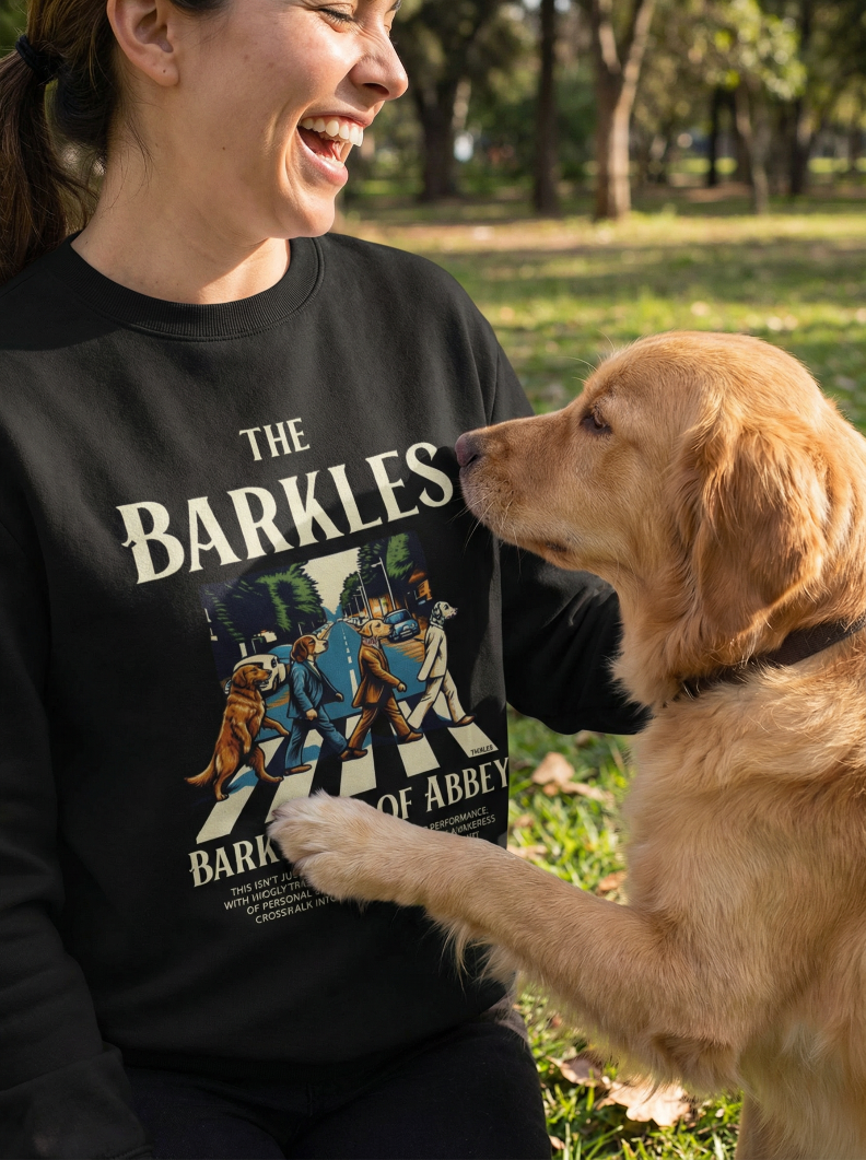 Woman wearing black Barkles dog sweatshirt in park with golden retriever