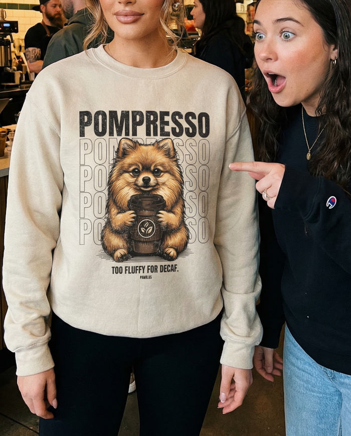 Two women in a coffee shop, one wearing a sweatshirt with a dog graphic and text.